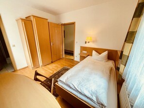Ein Hotelzimmer mit Bett, Schreibtisch, Kleiderschrank und Lampe.
