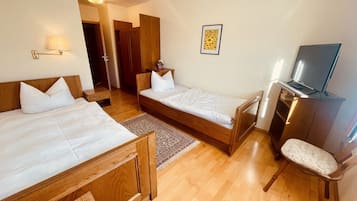 Une chambre d’hôtel avec deux lits, une télévision et un bureau.