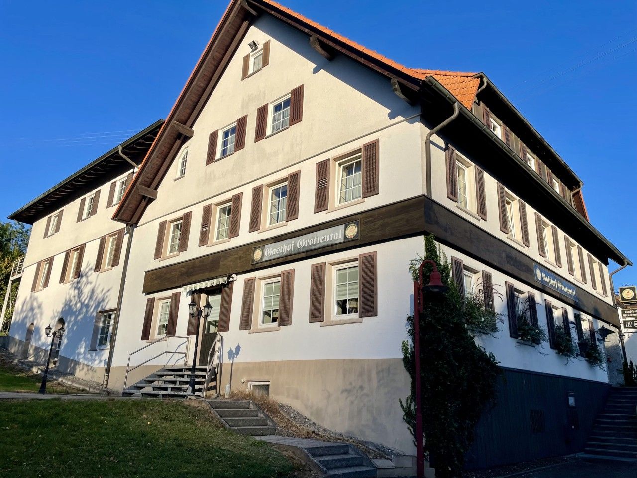 Un immeuble à plusieurs étages, sur lequel on peut lire une enseigne indiquant qu’il s’agit d’une maison d’hôtes ou d’une auberge.