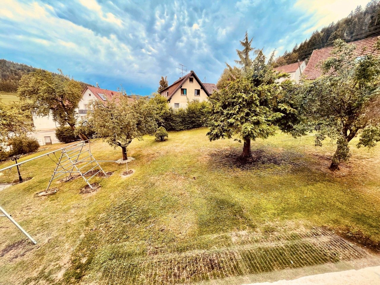 Ein Wohngebiet mit Häusern, einem Rasen und Bäumen.