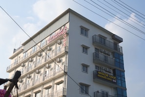 A multi-story building with balconies and air conditioning units. - Anugraha Lodge (Ramanagara)