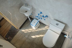 A bathroom with a toilet, sink, and bidet. - Anugraha Lodge (Ramanagara)
