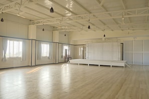 A spacious room with high ceilings, large windows, and a central area with a platform.