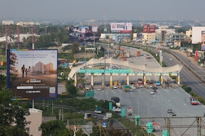A busy toll plaza with multiple lanes and vehicles. - Anugraha Lodge (Ramanagara)