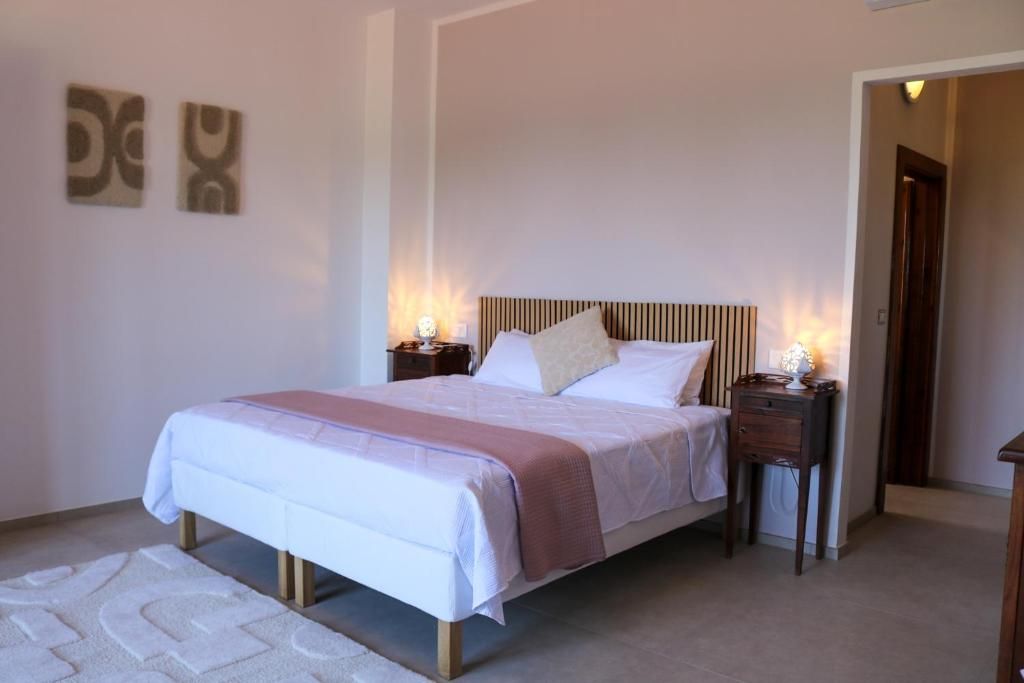 Ein Schlafzimmer mit einem Bett, Nachttischen und Wandbildern.