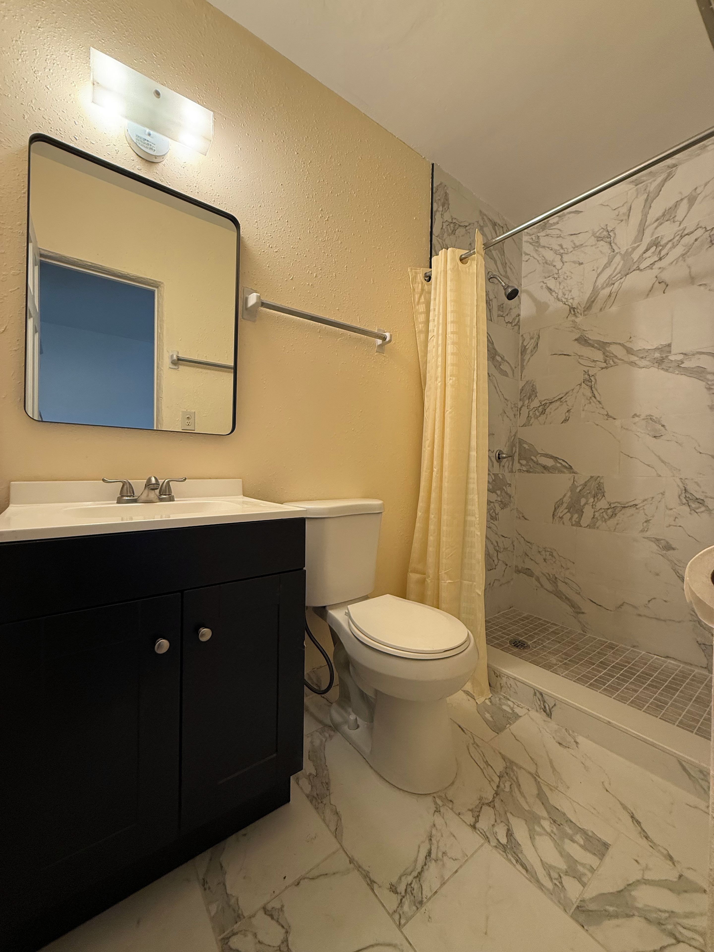 A bathroom with a sink, toilet, and shower.