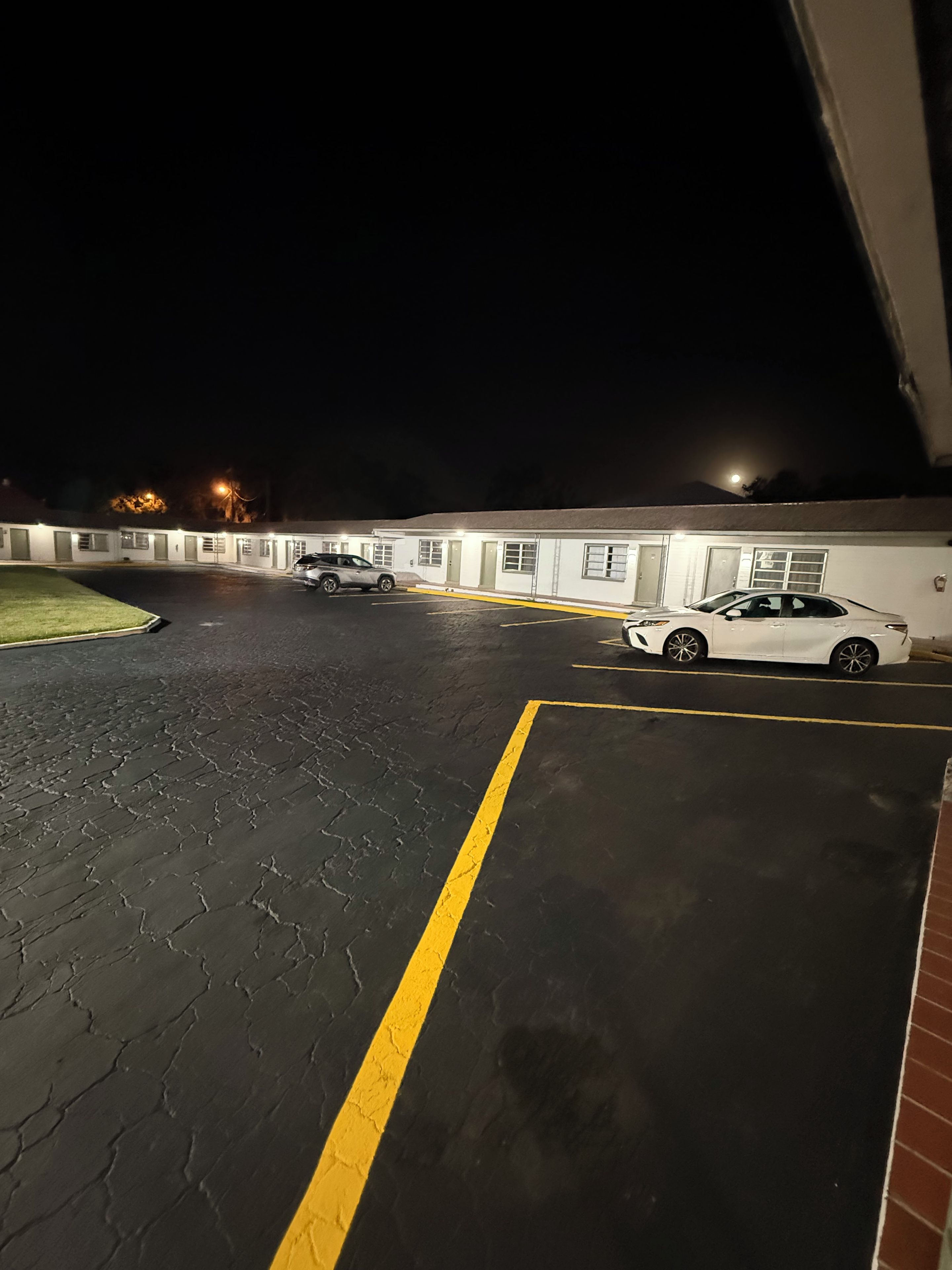 Un espace de stationnement où une voiture blanche est garée dans un emplacement prévu à cet effet.