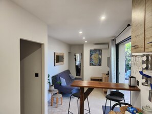 Een modern interieur met een eethoek, een bank, een kaart aan de muur, en een raam met gordijnen.