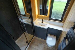 Ein kleines Badezimmer mit Waschbecken, Spiegel und Toilette.