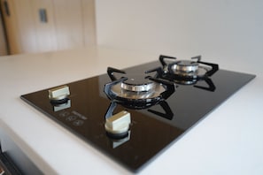 Une cuisinière à gaz dotée de quatre brûleurs et d’un panneau de commande.