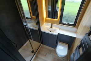 Ein kleines Badezimmer mit Waschbecken, Spiegel und Toilette.