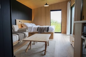 Ein modernes Schlafzimmer mit einem Bett, Nachttischen, einer Couch und einem Holztisch.