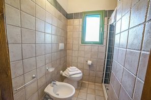 A bathroom with a toilet, bidet, and a window. - Borgo Primizia Room 23 B&B (Otranto)