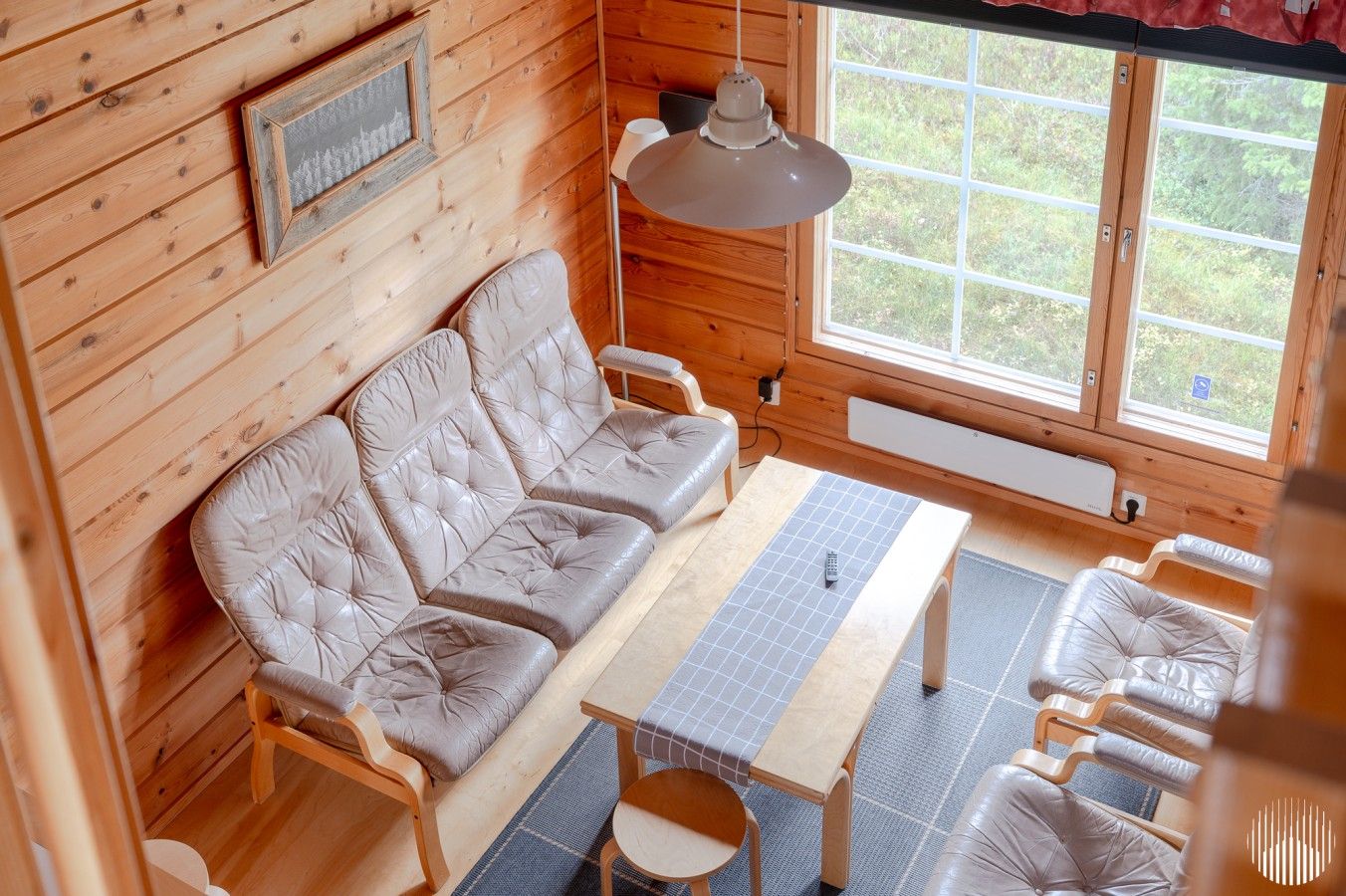 A cozy cabin interior with a sofa, a table, and chairs.