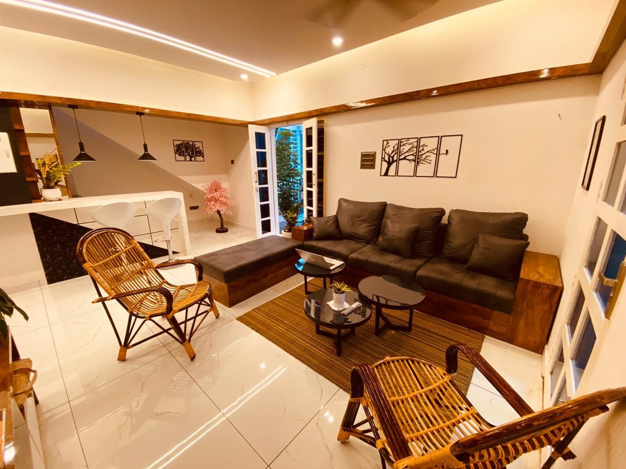 A modern living room with a sofa, two armchairs, a coffee table, and a dining area with a bench.