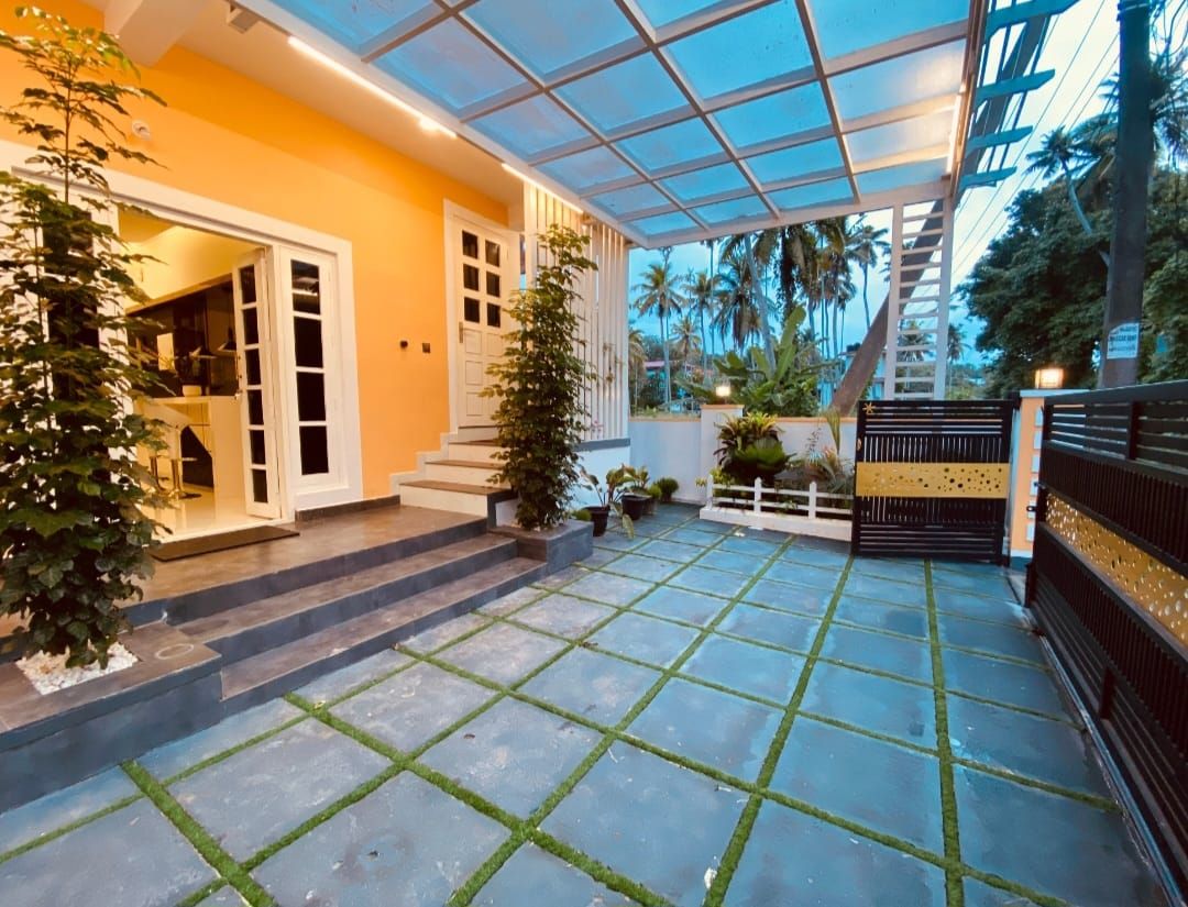 A covered outdoor area with a tiled floor, steps leading to a door, and a gate.