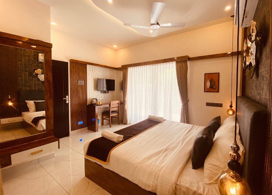 A hotel room with a bed, a desk, a chair, a television, and a mirror.