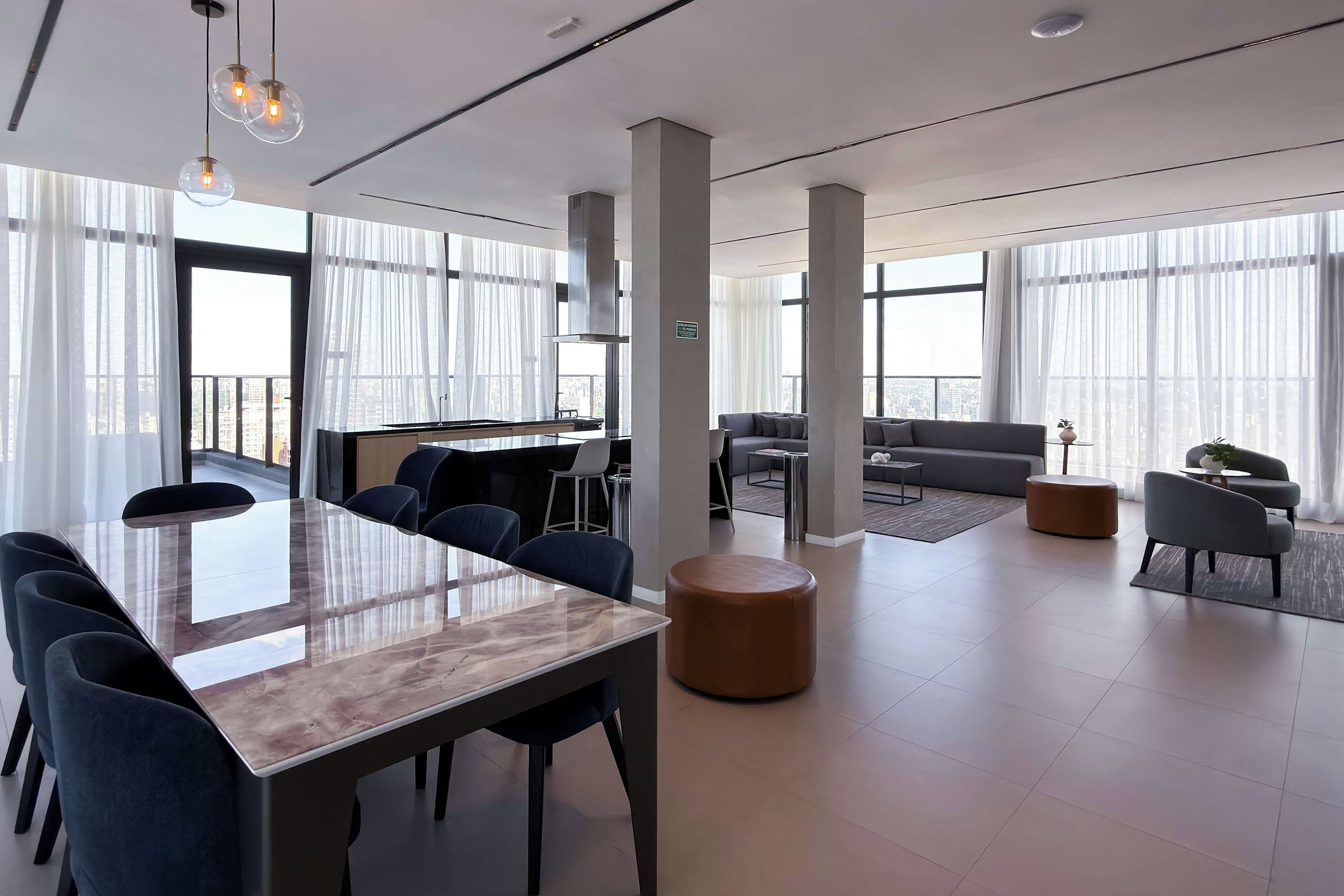 A modern office space with a large glass table, multiple chairs, a sofa, and a coffee table.