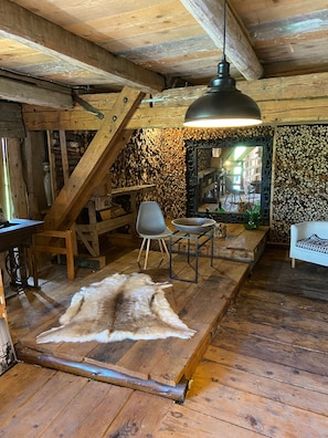 A rustic interior with a wooden ceiling, a fur rug, a dining table, and a chair. - Country House 'Allgäu-Cottage' with Mountain View, Private Terrace and Wi-Fi (Weiler-Simmerberg)