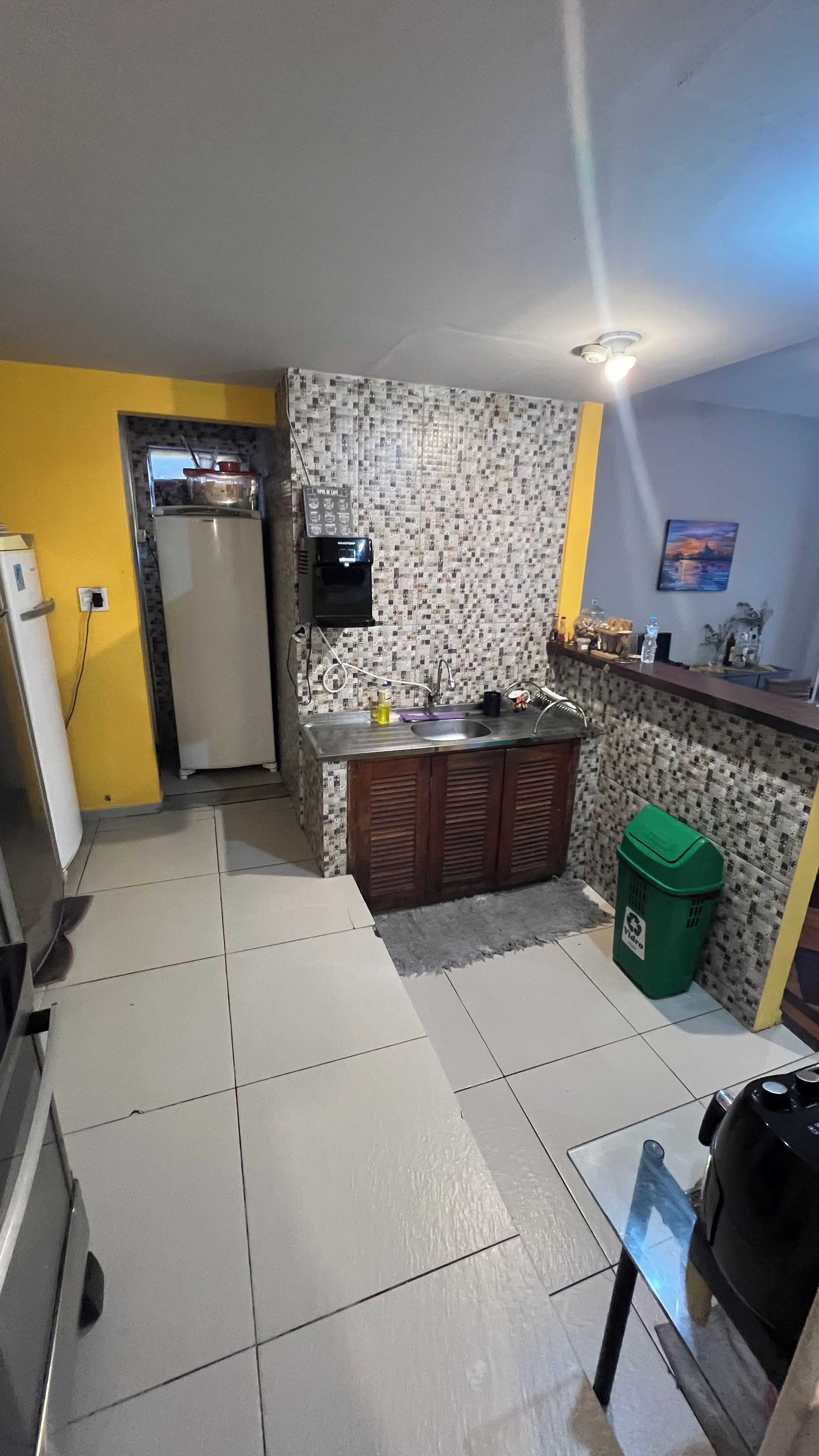 Una cocina compacta equipada con refrigerador, lavamanos y microondas.