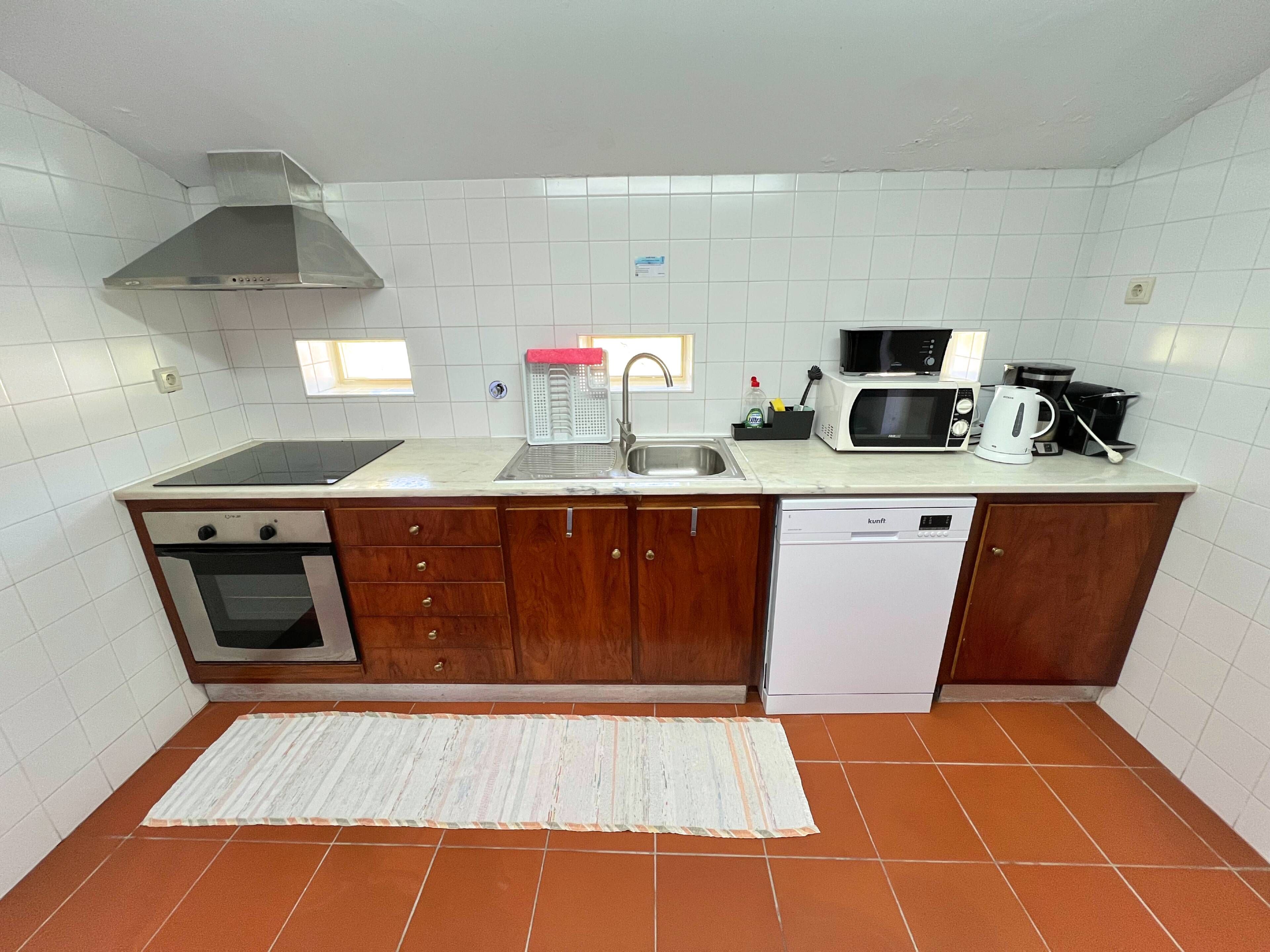 A compact kitchen with a stove, oven, microwave, and dishwasher.