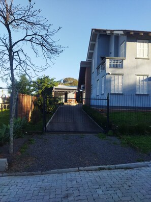 A gated entrance to a residential building with a paved driveway leading to the entrance. - New Listing (Vera Cruz)