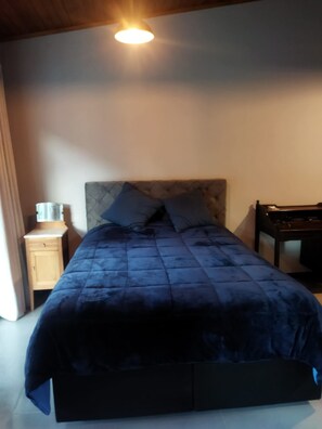 A bed with a headboard, a bedside table, and a lamp. - New Listing (Vera Cruz)