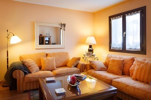 Ein Wohnzimmer mit zwei Sofas, einem Couchtisch und zwei Lampen.
