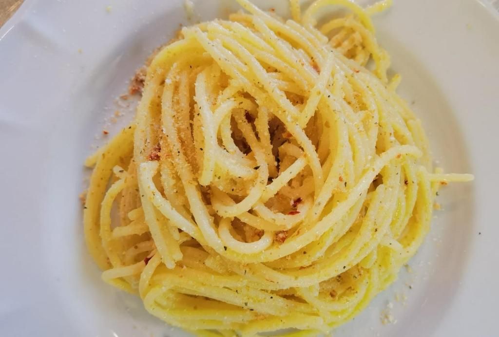 Un plato de espagueti con una capa ligera de condimentos.