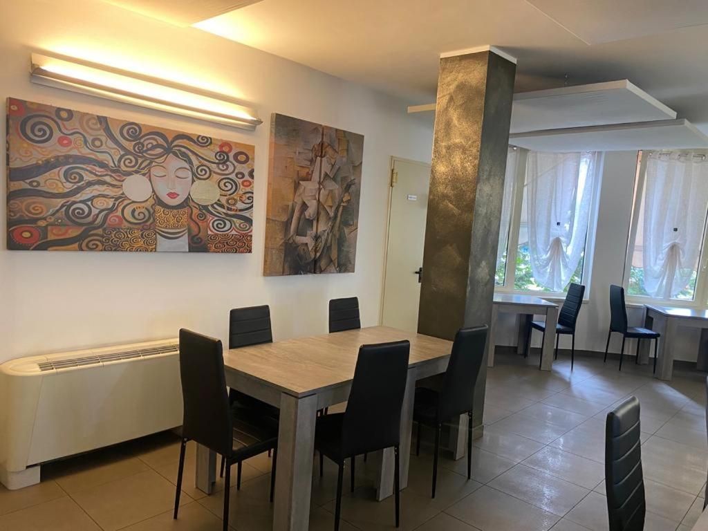 Un comedor con mesa y sillas, una obra de arte en la pared y un pilar grande.