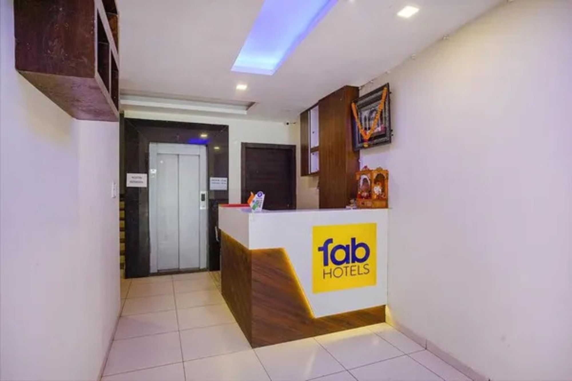 A reception desk with a sign for 'fab hotels' and a door leading to another room.