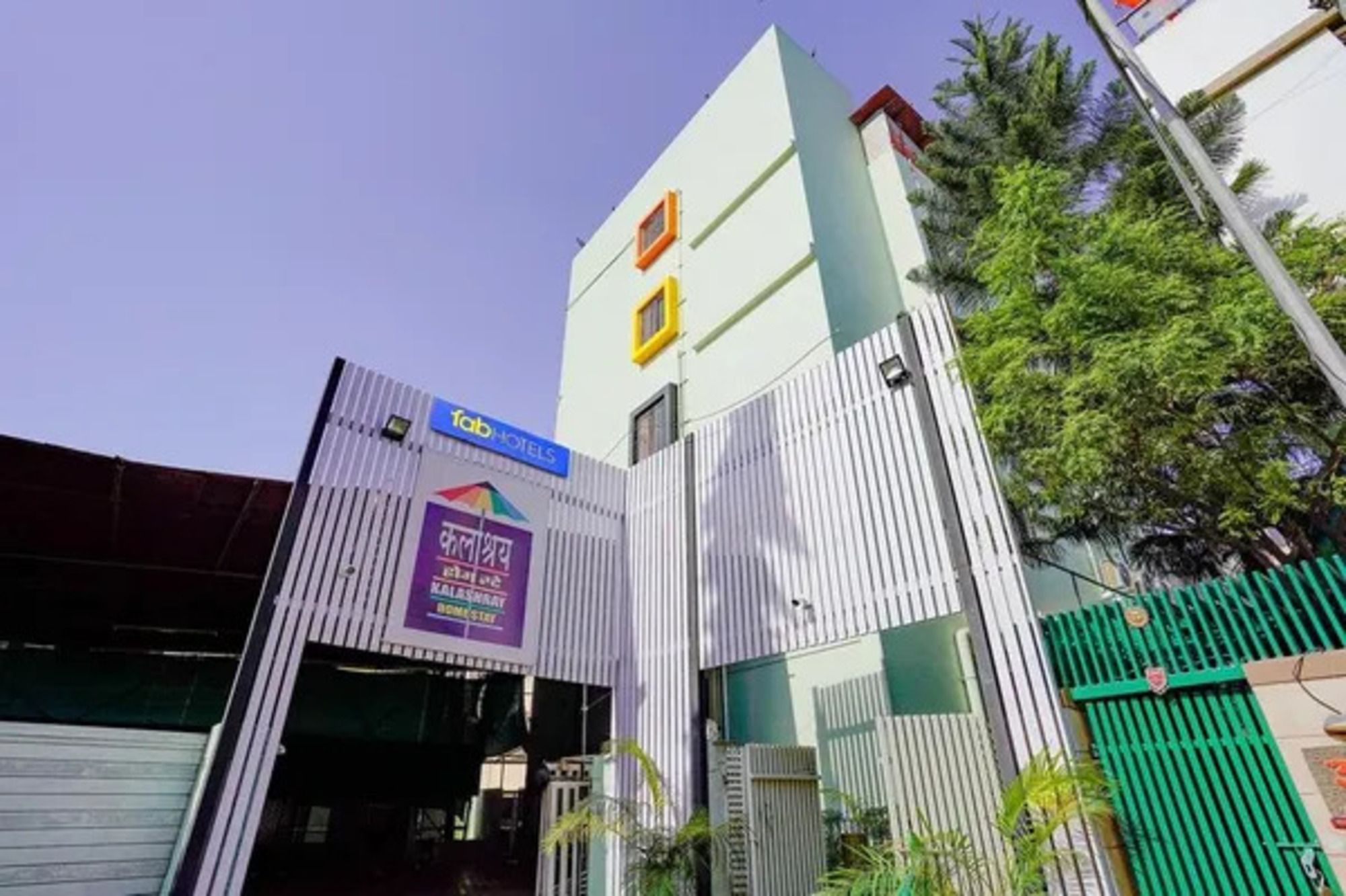 A hotel entrance with a sign for 'Tab Hotels' and a partially visible sign with text in a non-Latin script.