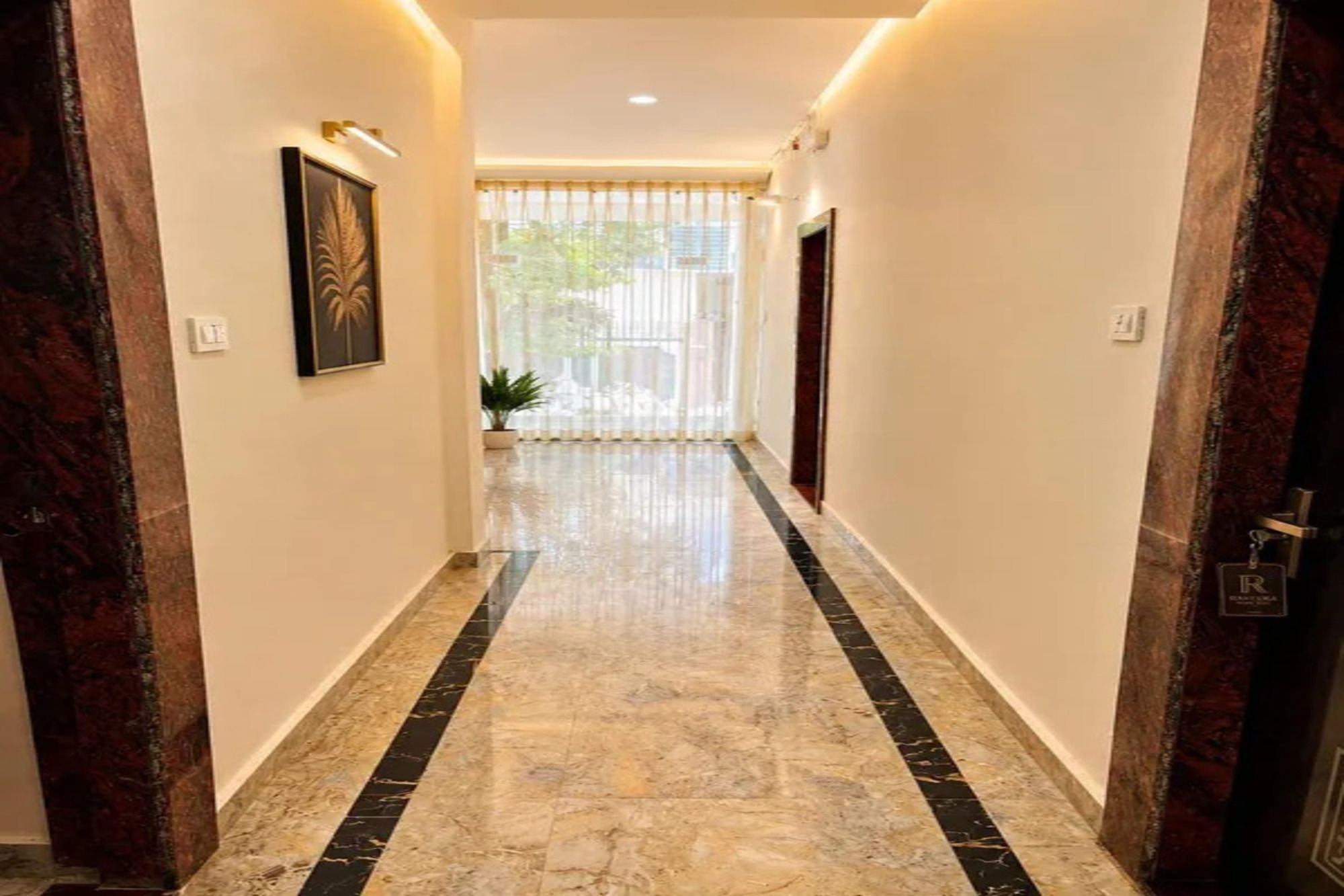 A hallway with marble flooring and a plant in the distance.