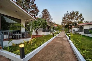 A pathway leading to a building with a covered porch and a small garden area with plants. - FabHotel Amore Serenity Resort (Arambol)