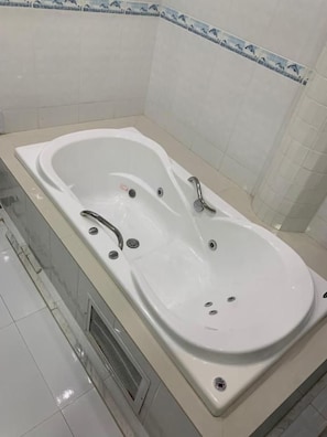 Ein Badezimmer mit einer großen weißen Badewanne, einer Dusche und einem WC.