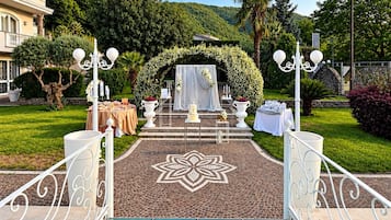 Un área de piscina con un sendero despejado que lleva a un arco decorado.