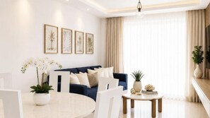 Un salon moderne avec un canapé bleu, une table basse blanche et des œuvres d’art encadrées accrochées au mur.