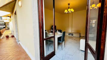 Un comedor con una mesa preparada para dos personas, un candelabro y vistas al balcón exterior.