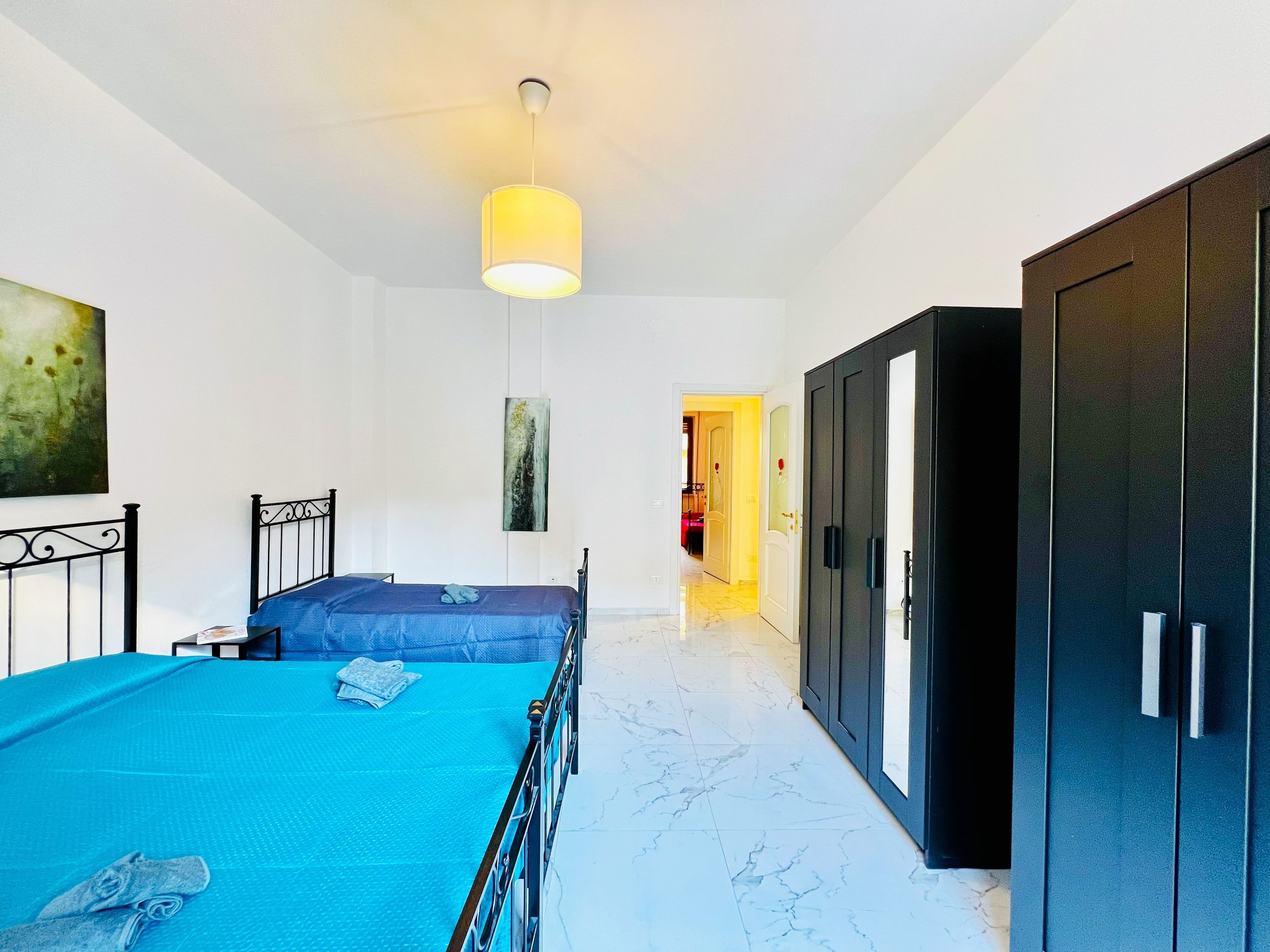 Un dormitorio con cama, armario y un cuadro en la pared.