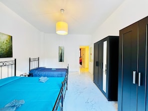 Un dormitorio con cama, armario y un cuadro en la pared.