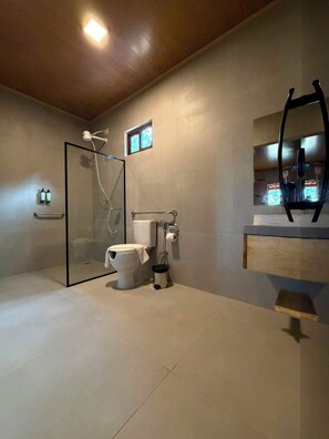 A modern bathroom with a glass shower enclosure, a toilet, and a sink with a mirror. - Pousada Engenho (Água Branca)