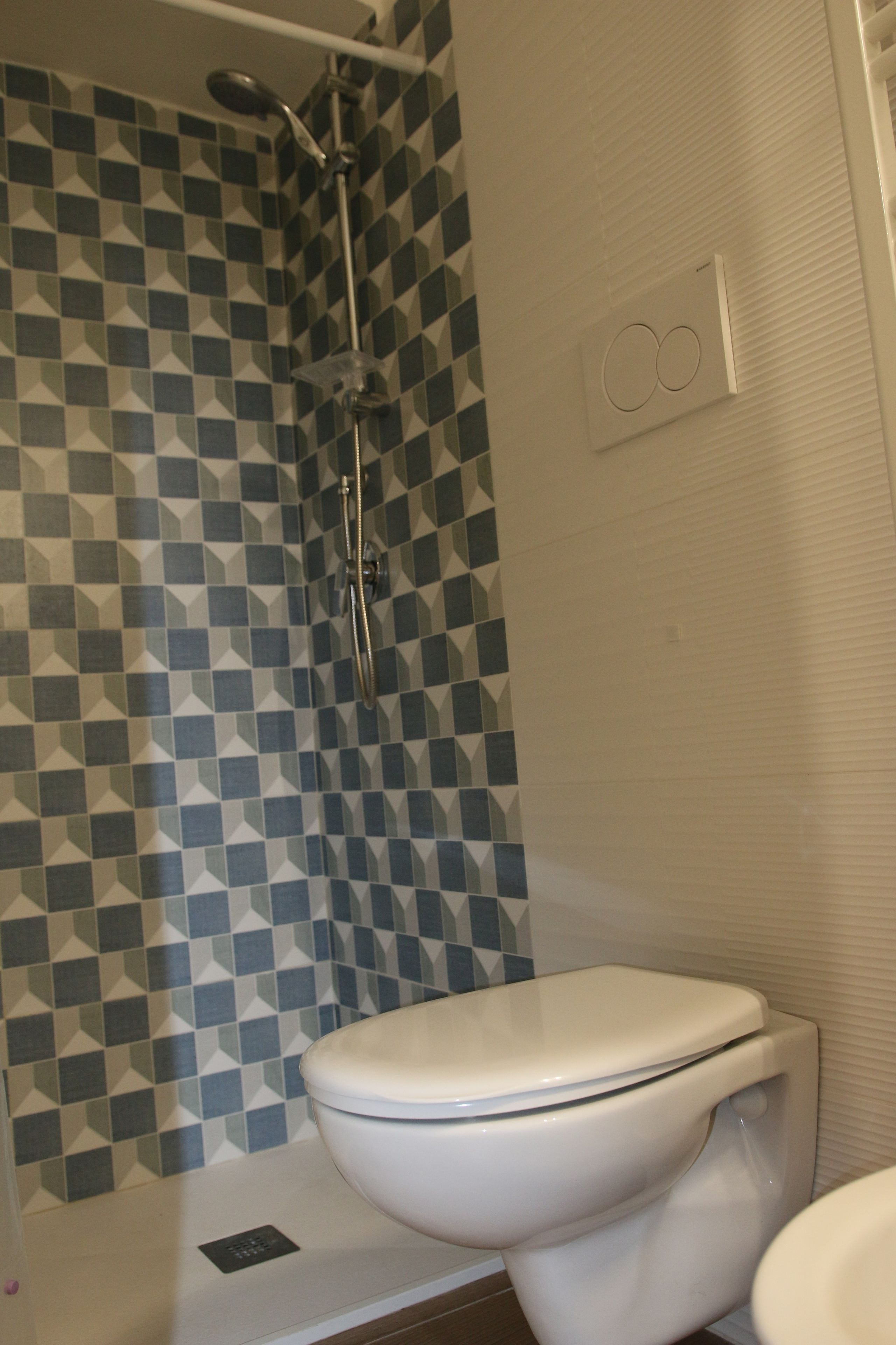 Un bagno con doccia, WC e parete decorata.