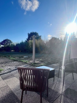 An outdoor seating area with two chairs and a table, surrounded by a garden and trees. - New Listing (Chaumes-en-Retz)