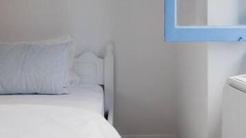 A bedroom with a bed, a radiator, and a window with blue trim.