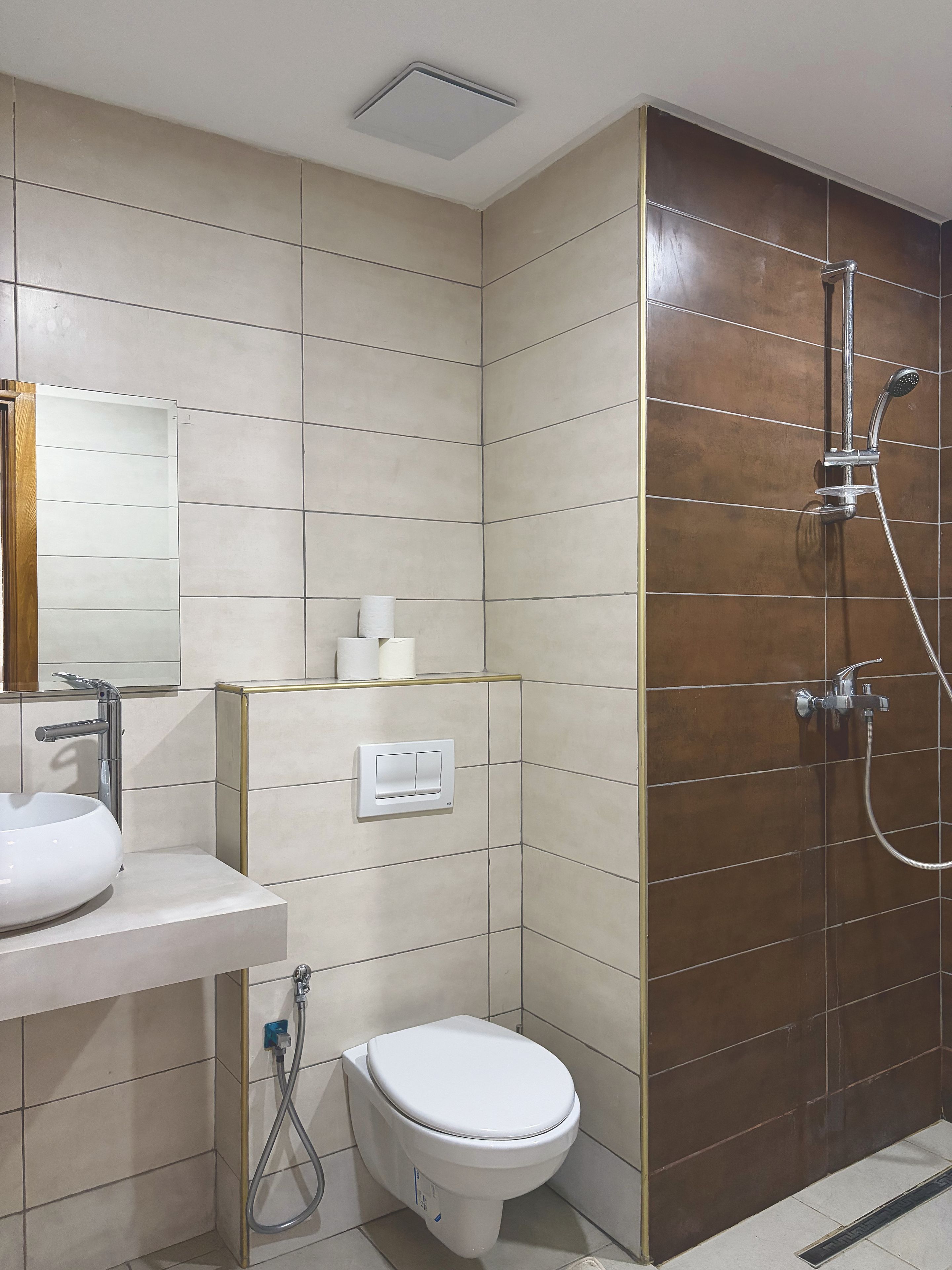 Een moderne badkamer met toilet, wastafel en douche.