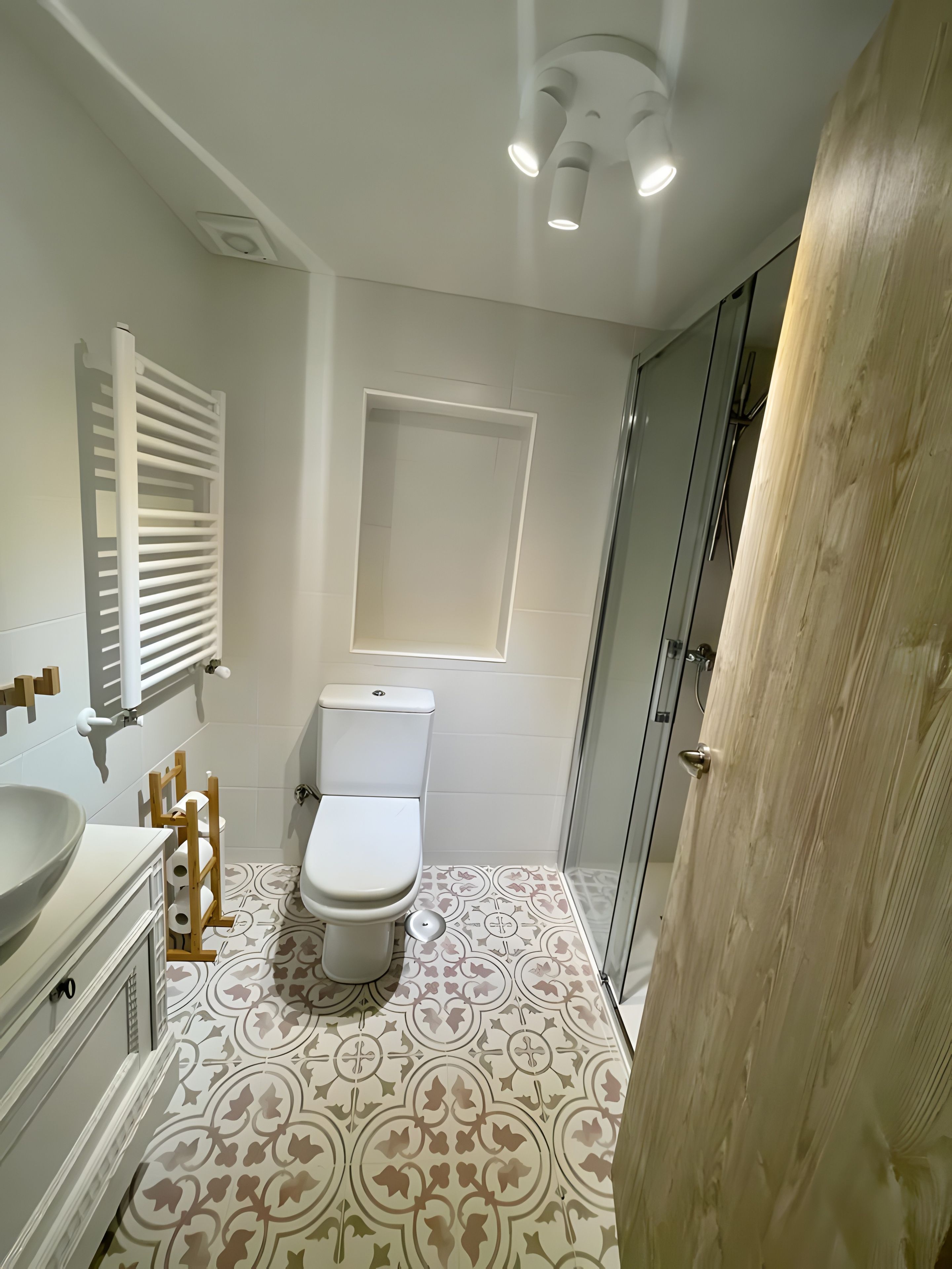 Un baño moderno con inodoro, lavabo y zona de ducha.