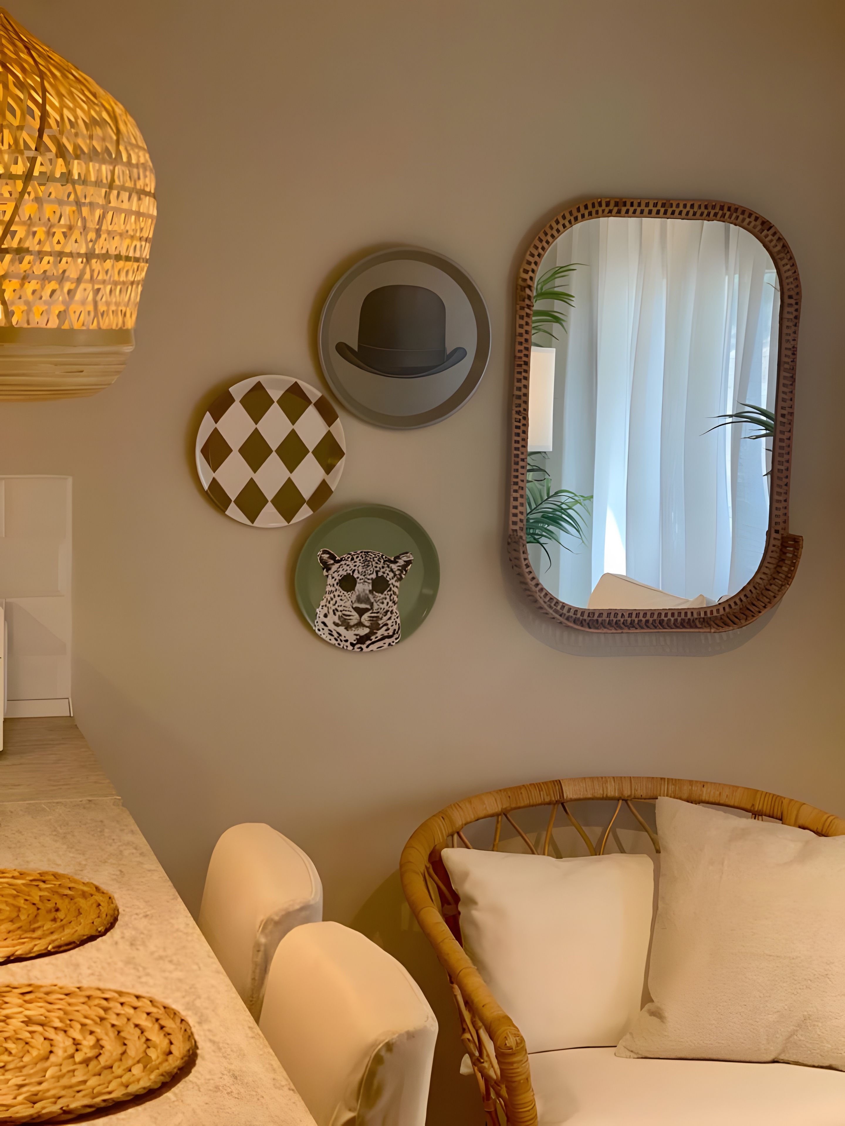 Een kamer met een rieten stoel, een spiegel en wanddecoraties, waaronder een hoed en een luipaardenkop.