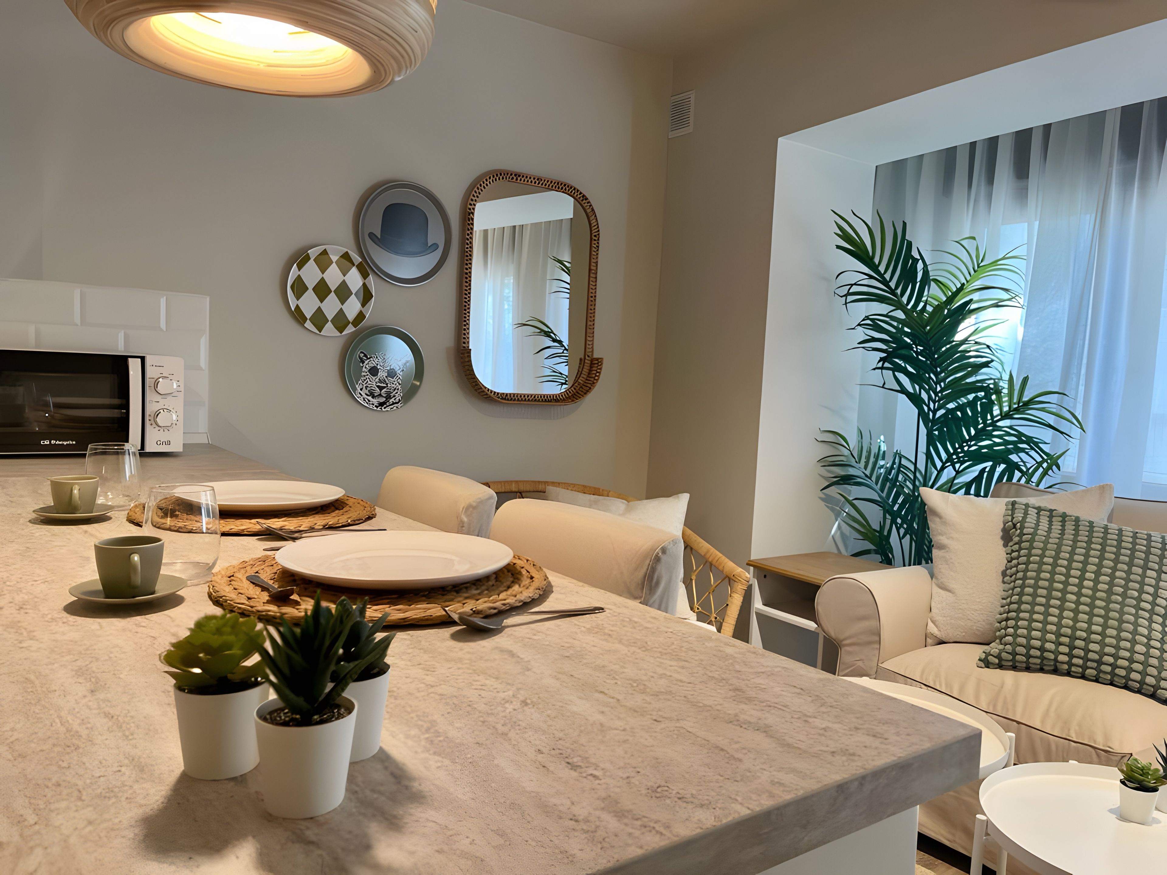 Una sala moderna con comedor, microondas y una planta grande.