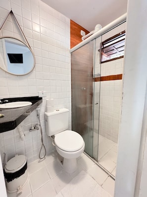 A bathroom with a toilet, sink, and shower area. - Pousada Boas ondas (Ipojuca)
