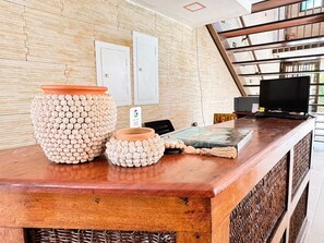 A reception desk with a woven basket, a terracotta pot, and a small bowl. - Pousada Boas ondas (Ipojuca)